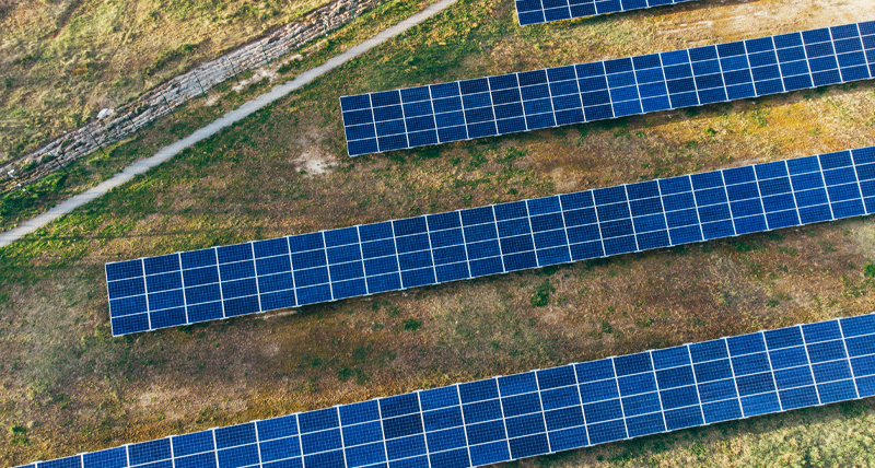 Vue aérienne d’une ferme solaire avec des panneaux disposés en rangées parallèles, montrant la capacité du Pegasus TRK100 à documenter et gérer les structures de transport et publiques avec une cartographie de haute précision.